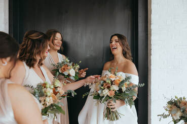 A bride laughs with her bridesmaids at the 405 Wedding Venue