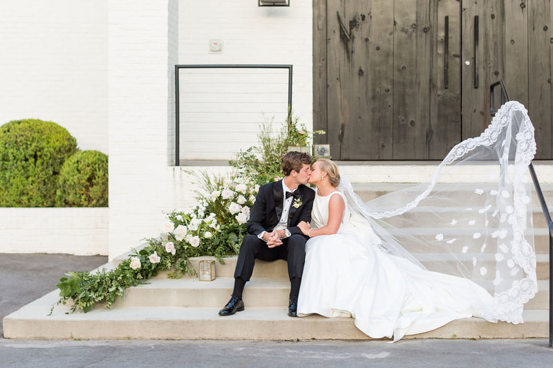 A couple kisses on the front steps of the 405 Wedding Venue in Downtown Greenville.